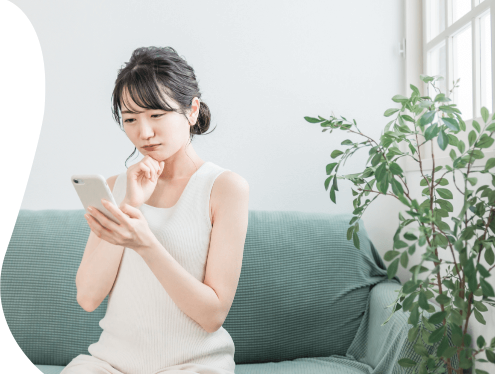 スマートフォンを眺める女性の写真